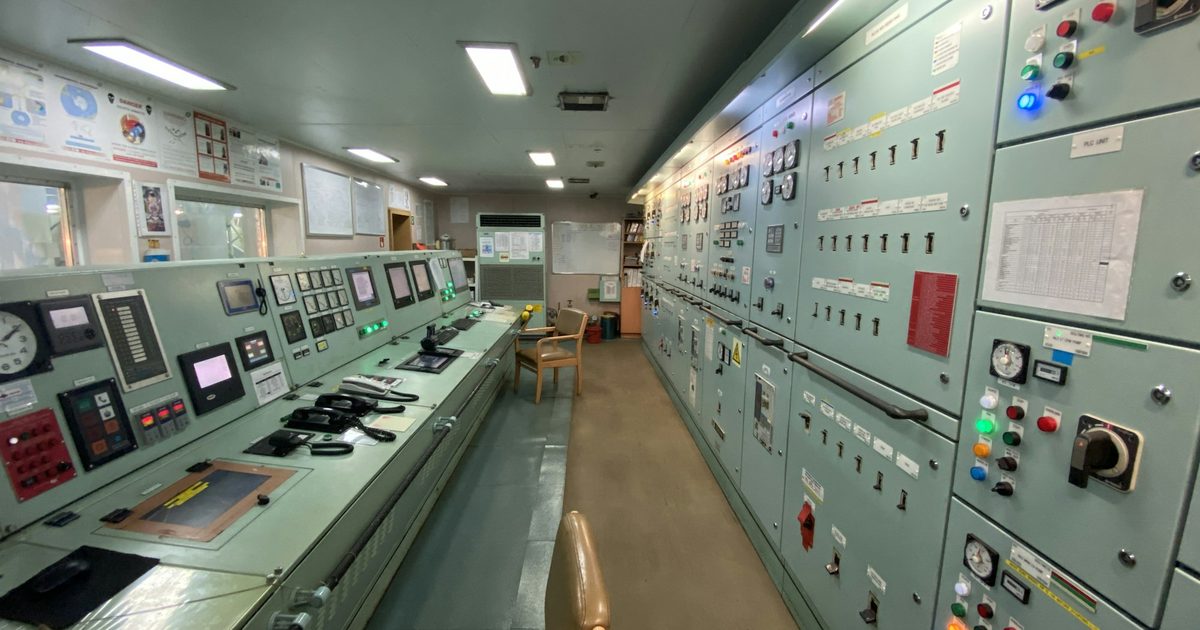 A control room lined with instrument panels and monitoring equipment