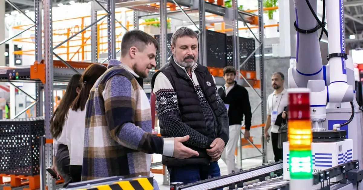 Two workers watching items move along an automated line in a warehouse