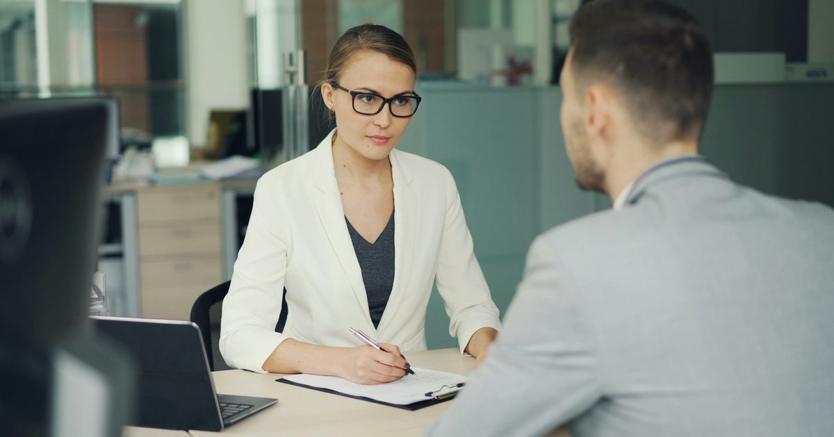 Two people talking across an office desk during an interview