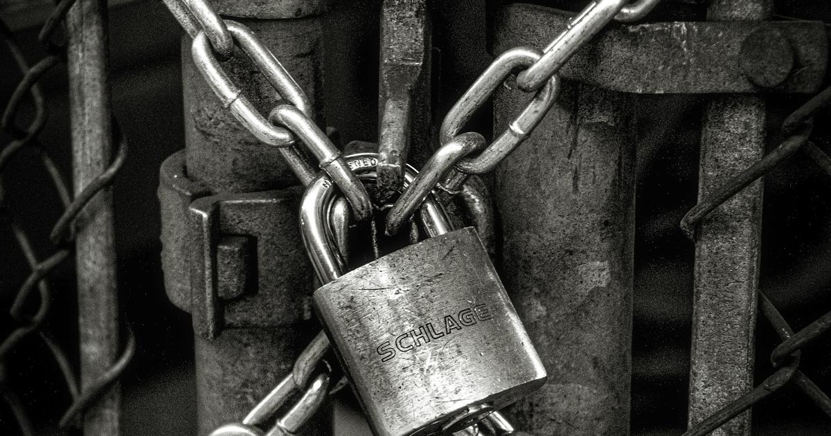 A heavy chain and padlock holding a gate closed